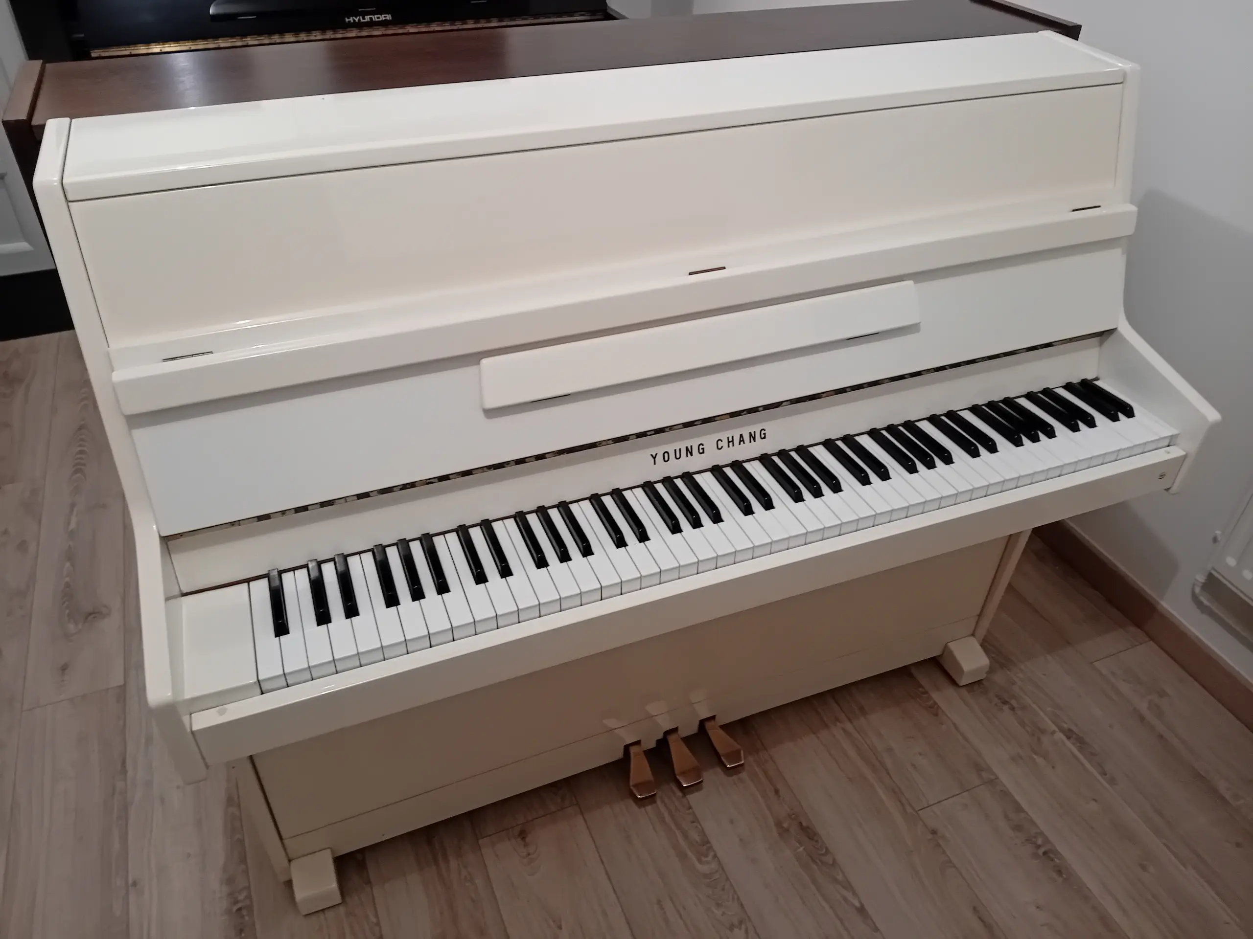 Piano droit Young Chang U109 ivoire, révisé, vue de trois quarts